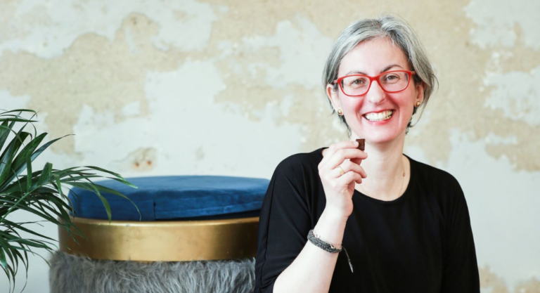 Estelle Tracy est assise et déguste un morceau de chocolat.