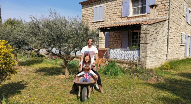 Nelly, son mari et leur fils avec des tee-shirts floqués de drapeaux Américains dans un jardin devant une maison