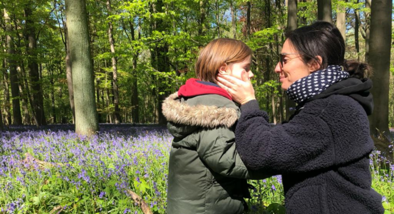 Deborah Laurent de profil en foret qui tient le visage de son fils entre les mains